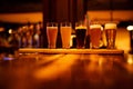 Various types of craft beer in small glasses on a wooden table in a pub. Royalty Free Stock Photo