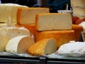 delicious large cut round soft cheese pieces on display in yellow and white