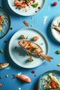 Various types of fish and seafood cooked on a bright colorful background