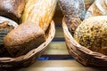 Various types of fresh bread in basket on shelf in bakery Royalty Free Stock Photo