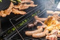 Various types of meat, chicken, sausages, blood sausage, lamb on a crbon grill in the garden