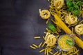 Various types of pasta with basil on a kitchen wooden table. The concept of Italian food. Royalty Free Stock Photo