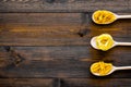 Various types of pasta concept. Fusilli, penne, fettuccine in spoons on dark wooden background top view copy space Royalty Free Stock Photo