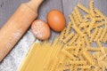 Various types or raw Italian pasta on the wooden rustic background and ingredients for pasta. Top view, flat lay. Royalty Free Stock Photo