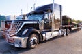 Various types of trucks in the parking lot next to the motorway. Truck stop