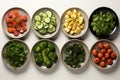 various types of vegetables sitting in small black bowls. Healthy snack foods with small bowls. Small breakfast bowls