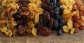 Various varieties of raisins on woody texture background. Royalty Free Stock Photo