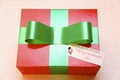 Red coloured gift box with green ribbon
