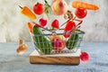 Various vegetables and fruits flying and falling into a supermarket basket standing on a wooden podium. Abundance and delivery Royalty Free Stock Photo