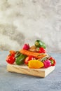 Various vegetables and fruits lying on a wooden podium, on a blue-gray background Royalty Free Stock Photo