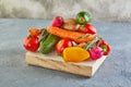 Various vegetables and fruits lying on a wooden podium, on a blue-gray background Royalty Free Stock Photo