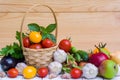 Various vegetables and fruits in a wicker basket on a wooden table Royalty Free Stock Photo