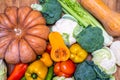 Various vegetables are laid out on a wooden table. Large assortment of vegetables food. pumpkin cabbage broccoli pepper