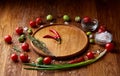 Various vegetables, seasoning and spicies around blank plate on rustic wooden background, top view Royalty Free Stock Photo