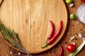 Various vegetables, seasoning and spicies around blank plate on rustic wooden background, top view Royalty Free Stock Photo