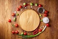 Various vegetables, seasoning and spicies around blank plate on rustic wooden background, top view Royalty Free Stock Photo