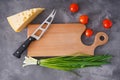 Various vegetables and wooden cutting board on a gray background, space for text. Flat lay Royalty Free Stock Photo