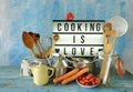 Various vintage kitchen utensils and sign with cooking is love message Royalty Free Stock Photo