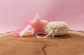 various wellness items on a wooden disc, against a pink background.