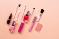 Various women makeup cosmetics on a pastel pink background. Blusher, lipstick, nail polish and brushes. Top view, flat lay, copy