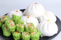 Varitirs steamed stuff bun and green chinese steamed dumpling with pork served in black disk Royalty Free Stock Photo