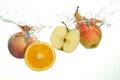 Apple slice, pear and orange splash in water in white Royalty Free Stock Photo