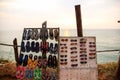 A street stall selling sunglasses and plastic slippers and flip flops on the beach in