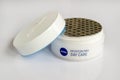 A jar of moisturizing face skin cream Nivea on a white background. White jar of face care cream sealed with foil close up