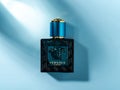 Varna, Bulgaria, January 03, 2022. Versace Eros perfume in a rectangular glass bottle on a bluee background. Stylish men perfume