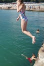 Girl jumping into the sea from the pier Royalty Free Stock Photo