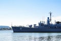 Large gray modern warship with radars and weapons leaves the port on a sunny summer day. Naval exercises, attack and defense