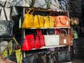 Modern fashionable yellow, red, white and brown leather handbags in a window of a haberdashery shop on a sunny spring day