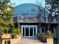 The entrance to the Planetarium and the Museum with a domed roof among the green trees and yuccas against the blue sky