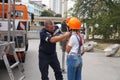 Firefighter puts on a teenage girl a protective helmet at a training session in the park