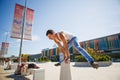 A young man jumps over the counter in front of the Varna airport near the waiting shops in the