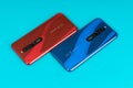 Varna, Nulgaria - May 16 , 2020: The back of Redmi 8 Android smartphones in Ruby Red and Sapphire Blue colour on blue background.