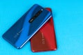 Varna, Nulgaria - May 16 , 2020: The back of Redmi 8 Android smartphones in Ruby Red and Sapphire Blue colour on blue background.