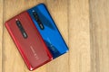 Varna, Nulgaria - May 16 , 2020: The back of Redmi 8 Android smartphones in Ruby Red and Sapphire Blue colour on wooden background