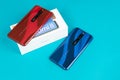 Varna, Nulgaria - May 16 , 2020: The back of Xiaomi Redmi 8 Android smartphones in Ruby Red and Sapphire Blue colour on blue