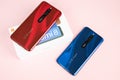 Varna, Nulgaria - May 16 , 2020: The back of Xiaomi Redmi 8 Android smartphones in Ruby Red and Sapphire Blue colour on pink