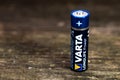 Varta longlife battery on aged weathered pine wood boards, copy space. Royalty Free Stock Photo