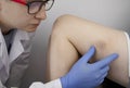 The vascular surgeon examines the outer thigh where the varicose veins are present. Preparation for laser treatment and