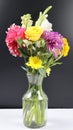 VASE WITH BEAUTIFUL COLORFUL BRIGHT FLOWERS ISOLATED IN DARK BACKGROUND. Royalty Free Stock Photo