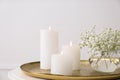 Vase with beautiful flowers and burning candles on table indoors, closeup. Interior elements Royalty Free Stock Photo