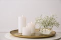 Vase with beautiful flowers and burning candles on table indoors. Interior elements Royalty Free Stock Photo