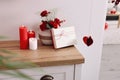 Vase with beautiful flowers, gift box and candles on wooden table indoors. Happy Valentine`s Day Royalty Free Stock Photo