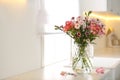 Vase with flowers on kitchen counter, space for text. Stylish element of interior design Royalty Free Stock Photo