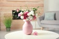 Vase with beautiful flowers on table in living room