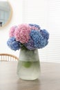 Vase with beautiful hydrangea flowers on wooden table indoors Royalty Free Stock Photo