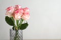 Vase with beautiful pink roses on light grey background, closeup. Space for text Royalty Free Stock Photo